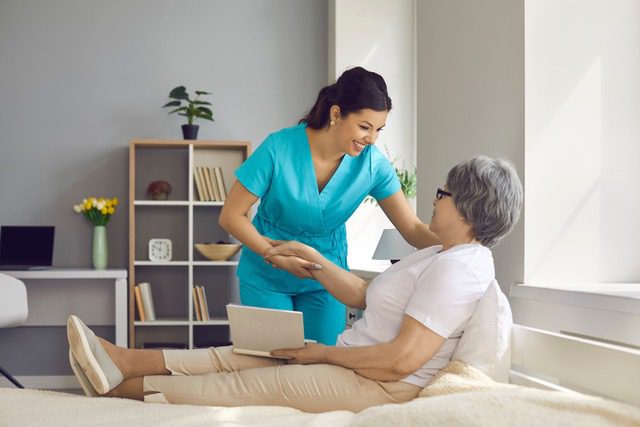 Joyful nurse taking care of senior mother<br />
